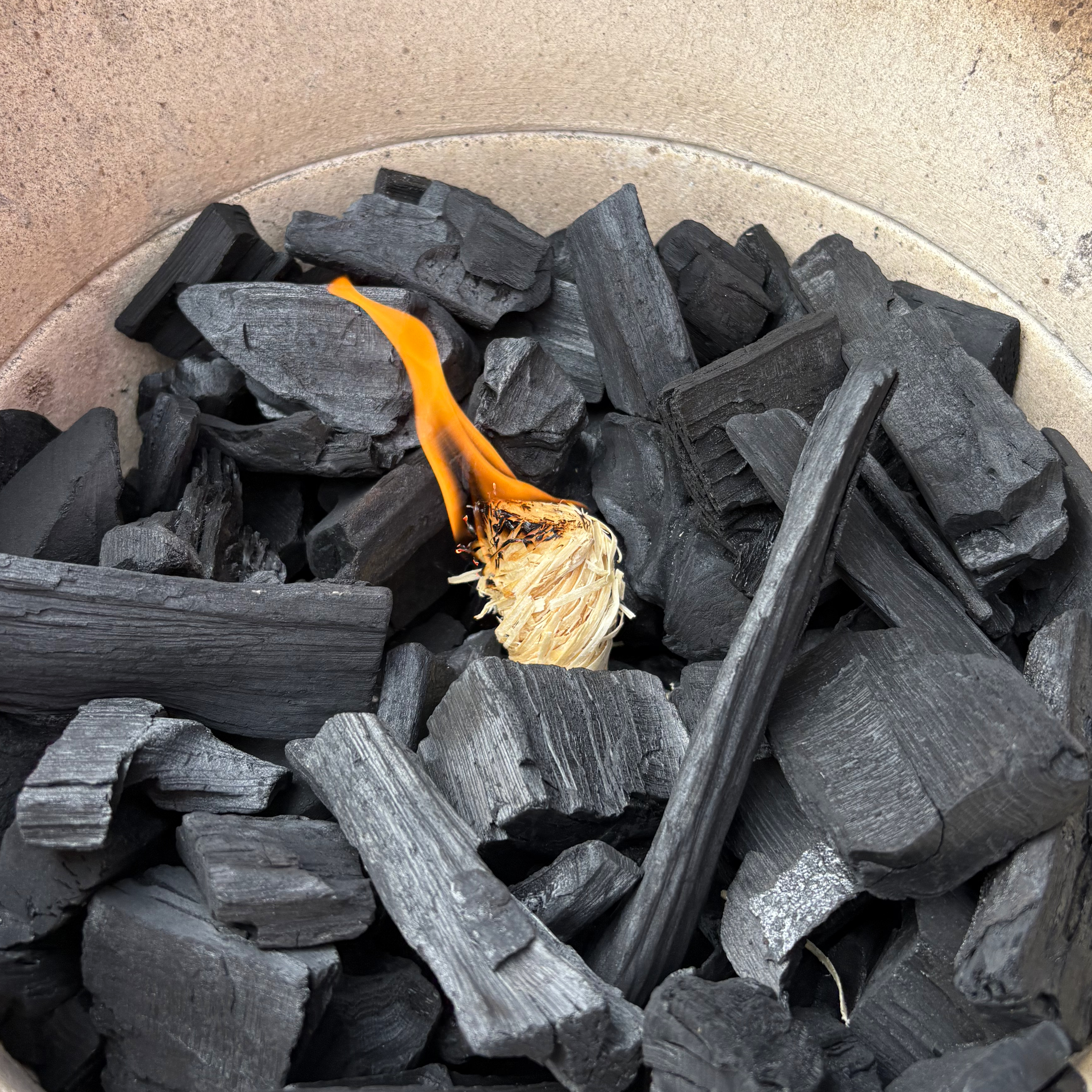 A STOCERS wood wool firelighter lighting charcoal in a kamado