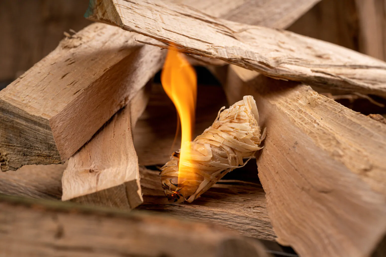 A STOCERS wood wool firelighter lighting a stack of firewood